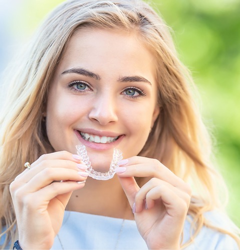 Young woman placing Invisalign® orthodontics tray