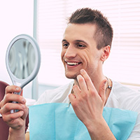 Young man admiring the results of his cosmetic dental treatment