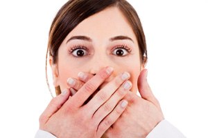 Woman covering mouth, embarrassed by imperfections in her teeth