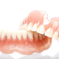 Full upper and lower dentures against white background