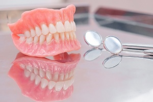 Full set of dentures in Watertown next to dental mirrors