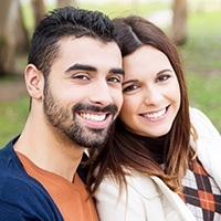 Man and woman smiling after treatment for toothaches