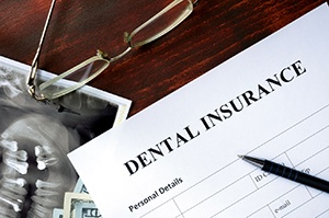 Dental insurance form with pen and eyeglasses
