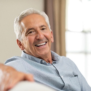 Smiling senior man with implant dentures in Watertown, MA
