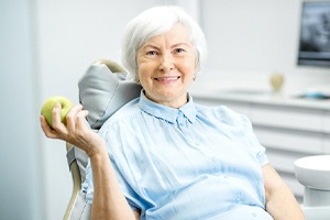 Senior female patient enjoying the benefits of implant dentures