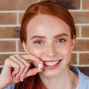 Woman holding up an extracted tooth