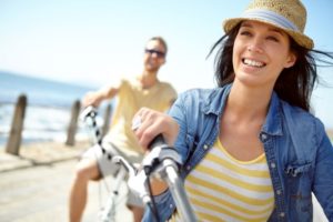 Woman smiling while riding bicycle on beach